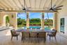 Covered patio featuring a beamed ceiling with dual overhead fans, stone flooring, a built-in outdoor kitchen, and pool with an integrated spa