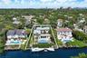Waterfront property featuring a multi-story residence, private swimming pool, integrated spa, and a bulkhead-lined dock on a canal