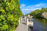 Waterfront dock featuring composite decking, vertical pilings, and a mechanical boat lift