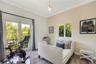 Room featuring wood-finish tile flooring, crown molding, glass-paned French doors opening to a balcony with decorative railing, and a pendant light fi