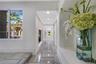 Hallway featuring polished stone flooring, recessed ceiling lighting, and a built-in recessed display niche