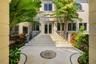 Grand entrance featuring a stone staircase, detailed tile inlay, symmetrical wrought iron railings, and dual glass-paned entry doors