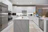Kitchen featuring white shaker cabinetry, a waterfall-edge center island with stone-finish countertops, stainless steel appliances, a professional-sty