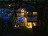 Two-story residence featuring a tile roof, an in-ground pool with integrated spa, a paved patio area, and a built-in outdoor fire pit