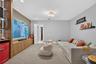 Custom built-in wood-finish cabinetry, textured accent wall, integrated recessed lighting, and flush-mount multi-bulb fixture