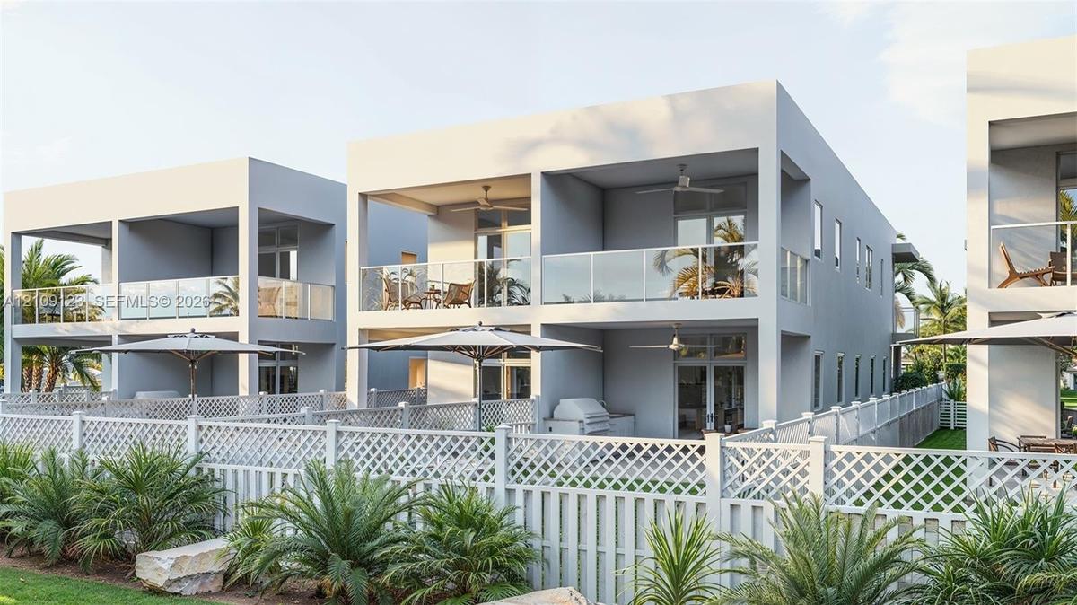 Contemporary multi-level structures featuring private covered balconies with glass railings, built-in outdoor kitchen components, and white lattice fe