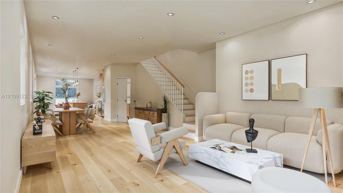 Open-concept floor plan featuring wood-finish flooring, recessed lighting, and a staircase with a wooden handrail and white balusters
