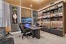 Custom floor-to-ceiling wooden shelving with integrated LED display lighting, slat-wood ceiling detail, vertical wall paneling, and wall-mounted track