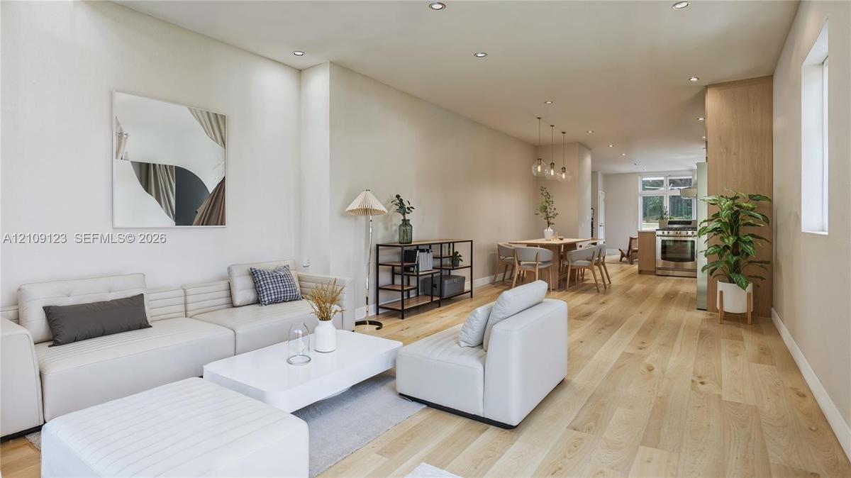 Open-concept interior featuring wood-finish flooring, recessed lighting, and wood-paneled cabinetry