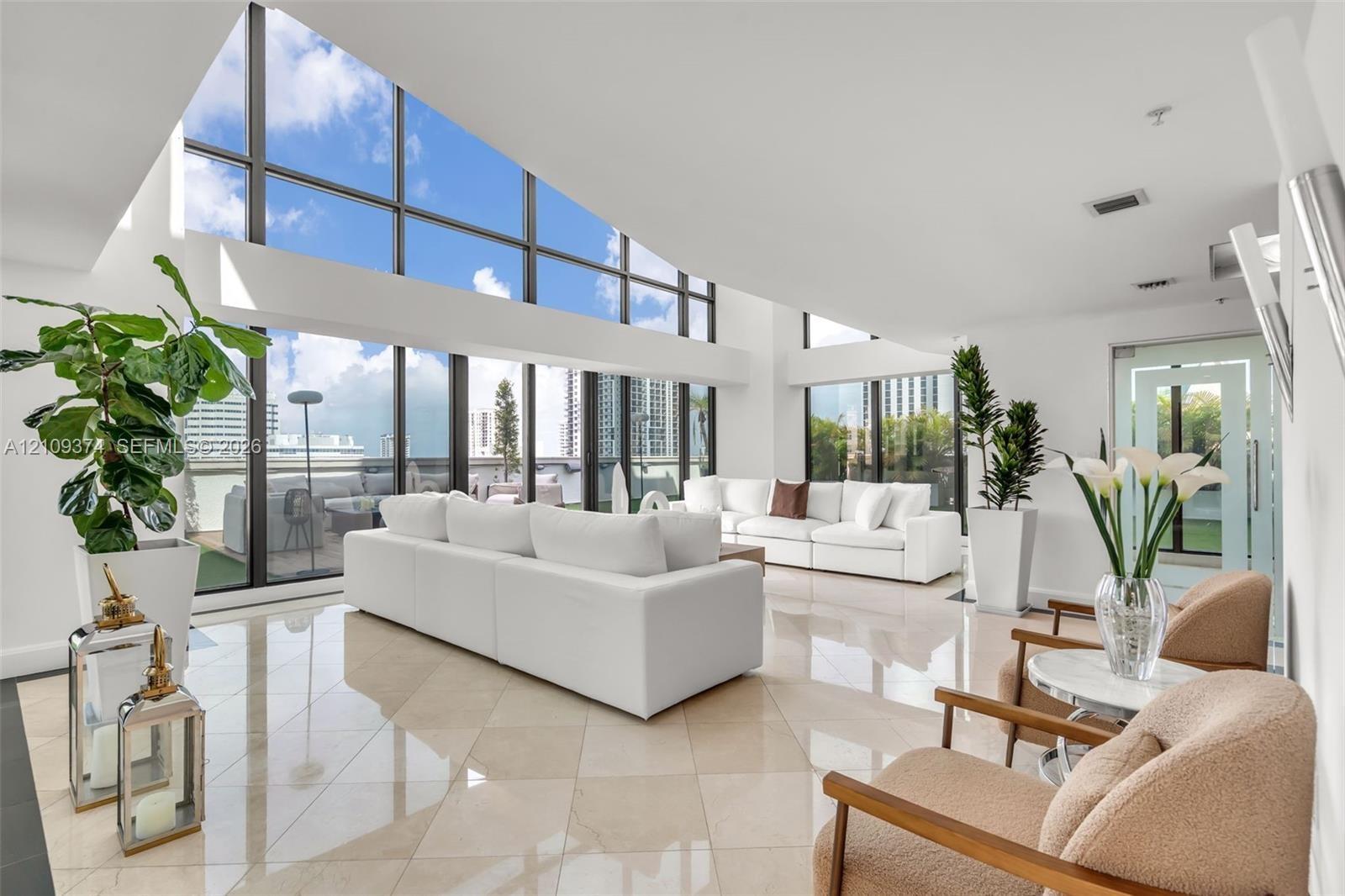 Vaulted ceilings featuring expansive floor-to-ceiling windows and polished stone tile flooring