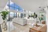 Vaulted ceilings featuring expansive floor-to-ceiling windows and polished stone tile flooring