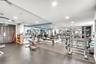 Fitness facility featuring wall-to-wall mirrors, recessed lighting, double-door entry, and resilient rubber flooring