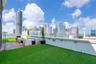 Rooftop terrace featuring synthetic turf, wood-finish decking, and perimeter wall-mounted lighting