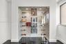 Custom climate-controlled display enclosure featuring floor-to-ceiling glass paneling, metal racking systems, integrated recessed lighting, and high-g