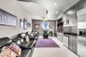 Curved architectural ceiling detail with recessed lighting, integrated cabinetry, stainless steel kitchen appliances, and neutral wall-to-wall carpeti