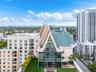 High-rise penthouse featuring an A-frame architectural design, expansive glass curtain wall, metal roofing, and a private rooftop terrace with artific