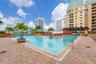 Swimming pool featuring integrated water features, a paver deck, and a shaded pergola structure