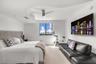 Custom tray ceiling featuring a curved architectural design, ceiling-mounted brushed-finish fan, wall-to-wall carpeting, and single-pane window