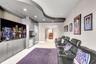 Custom built-in cabinetry with integrated microwave, stainless steel refrigerator, dishwasher, recessed ceiling lighting, and a distinctive curved arc