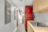 Utility room featuring light-finish cabinetry, a stainless steel sink with a high-arch pull-down faucet, and dedicated built-in shelving