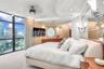 Floor-to-ceiling windows with urban scenery, custom wood-paneled wall accents, circular feature window, recessed ceiling lighting, and built-in wall-m