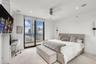 Floor-to-ceiling glass sliding doors, private balcony, recessed lighting, ceiling fan, and wall-mounted light fixtures