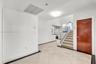 Entryway featuring large-format diagonal tile flooring, a solid wood-finish entry door, a staircase with a glass panel railing, and a decorative circu