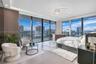 Floor-to-ceiling windows, wrap-around balcony with glass railings, large-format tile flooring, recessed cove lighting, and contemporary circular multi