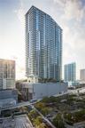 High-rise structure featuring floor-to-ceiling glass windows, wrap-around private balconies, and a multi-level concrete and glass exterior