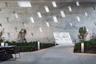 Architectural concrete wall featuring a geometric pattern of recessed window openings, cast-in-place construction, integrated landscape lighting, and 