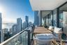 Covered balcony featuring floor-to-ceiling glass panel railings and expansive cityscape and water scenery