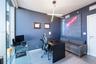Floor-to-ceiling glass panel, linear geometric pendant lighting, and smooth-finish stone flooring