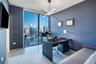 Floor-to-ceiling windows, modern linear chandelier, and neutral wall tones
