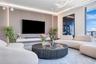 Living area featuring a floor-to-ceiling wood-panel accent wall, built-in floating media console, recessed perimeter lighting, and contemporary chande