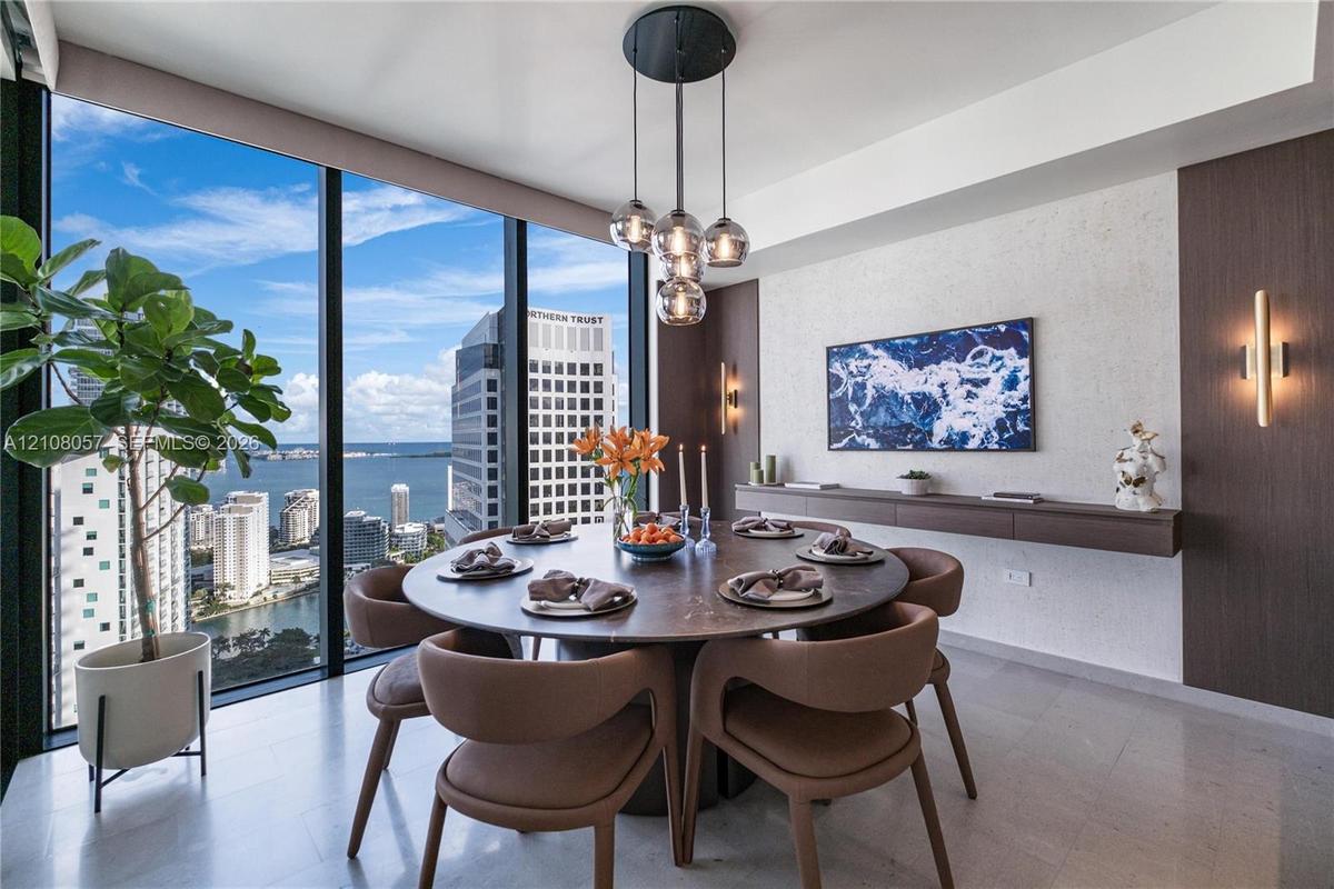 Floor-to-ceiling windows, stone flooring, custom-built wall-mounted console, multi-globe pendant lighting, and vertical wall-mounted accent fixtures