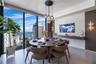 Floor-to-ceiling windows, stone flooring, custom-built wall-mounted console, multi-globe pendant lighting, and vertical wall-mounted accent fixtures