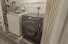 Laundry area equipped with a top-load washer, front-load dryer, and wall-mounted wire shelving