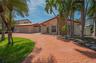 Single-story exterior featuring a stamped concrete driveway, decorative stone facade, tile roof, and attached garage