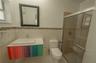 Bathroom featuring a floating vanity with a multicolored cabinet base, rectangular vessel sink, mosaic tile accent border, and a glass-enclosed shower