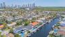 Aerial perspective featuring waterfront property with direct canal access, private boat dockage, and rooftop solar panel installation