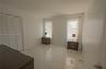 Interior space featuring large-format ceramic tile flooring, neutral walls, and a built-in closet with louvered double doors