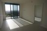 Floor-to-ceiling sliding glass doors, private balcony with metal railing, and neutral tile flooring
