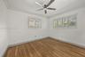Bedroom - 4 Wood-finish flooring, plantation shutters, crown molding, and a central ceiling fan