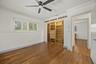 Bedroom 4 - Wood-finish flooring, custom built-in cabinetry, adjustable interior window shutters, ceiling fan, and crown molding
