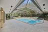 Screened-in pool enclosure featuring a covered patio, recessed lighting, and integrated pool entry railing