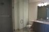 Bathroom featuring a walk-in shower with a frameless glass enclosure, vanity with stone-patterned countertop, under-mount sink, and multi-bulb integra