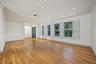 Open-concept interior featuring wood-finish flooring, recessed lighting, crown molding, and plantation shutters