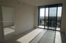 Large-format tile flooring, floor-to-ceiling glass sliding doors, and a private balcony with metal railings