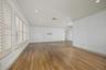 Living area featuring wood-finish flooring, recessed lighting, crown molding, and plantation shutters