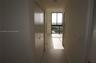 Hallway featuring large-format floor tile, double-door closet, and floor-to-ceiling windows